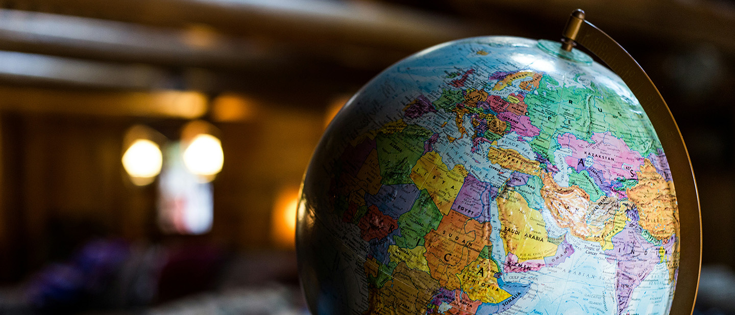 A world globe on a top in a dark moody room.