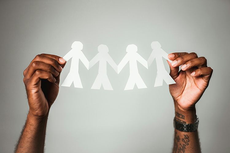 Person holding paper people chain